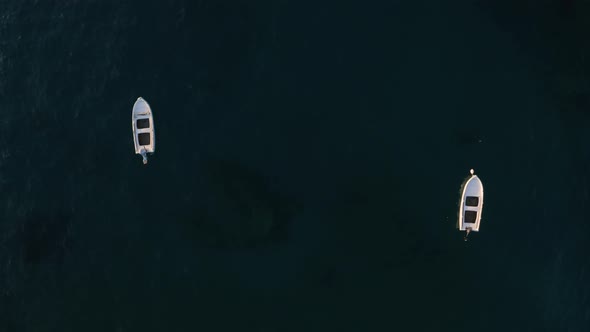 Top aerial view of Two Boats in Sea. Flying above boats in water. Concept footage  alt