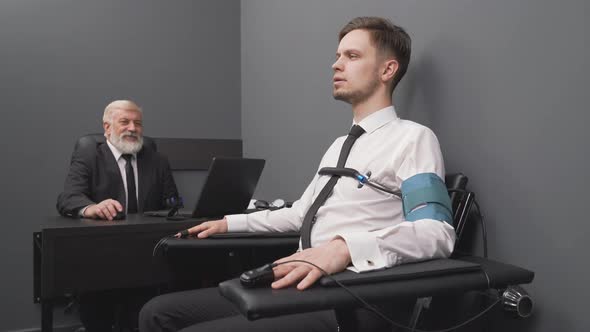 Senior Expert Checking Handsome Man with Computer Polygraph alt