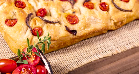 Traditional Italian Focaccia with cherry tomatoes, black olives and rosemary. alt