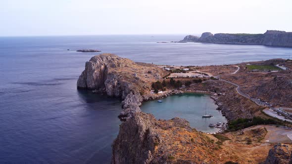 Aerial drone shot of naturally occurred lagoon in Lindos city in Greece alt