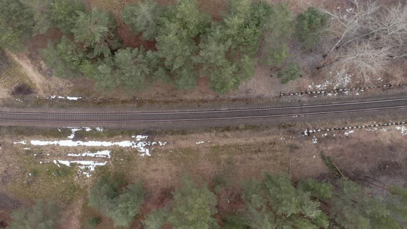 AERIAL: Railway in a Forest on a Gloomy Cloudy Day in Springtime alt