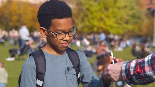 Portrait of African Preteen Boy Taking Cigarette From Dealer and Smoking alt