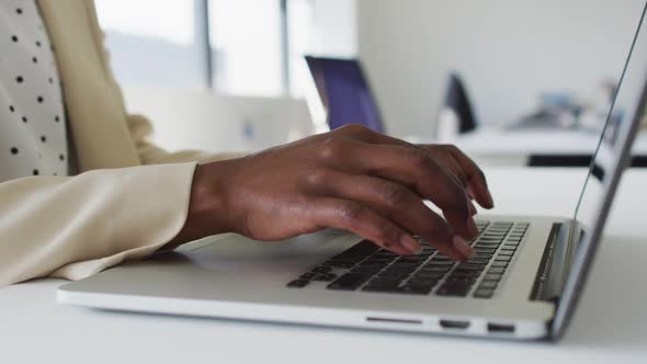 Close up of hands of african american businesswoman typing on laptop alt