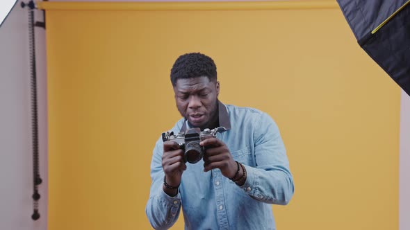 Attractive African American Male Photographer Making Photos Moving Hands and Showing Thumbs Up alt