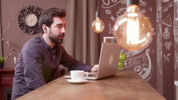 Handsome Man Having a Video Conference While Drinking a Coffee at a Bar alt