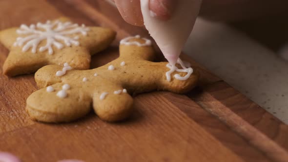 Decoration Process of Christmas Cookies in the Shape of Gingerbread Men with Icing alt