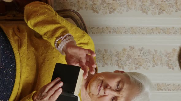 Senior Caucasian Woman Holding the Bible and Pondering Medium Shot Living Room Religion and alt