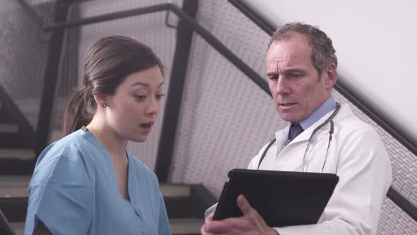 CU Doctor and nurse using tablet and discussing in hospital / London, United Kingdom.