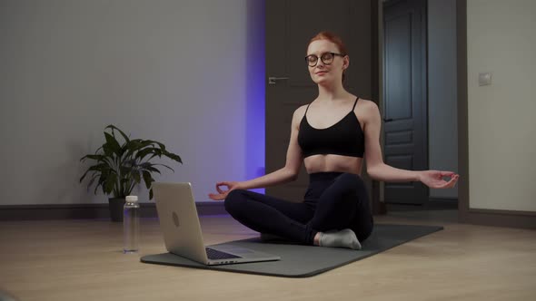 Girl with Glasses Meditating While Sitting on the Floor alt