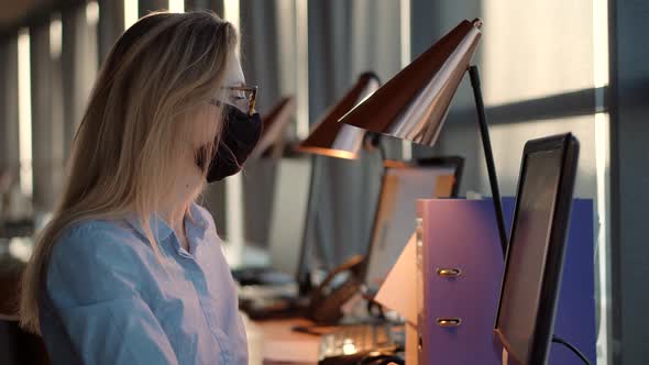 Girl In Face Mask Working In Office. Businesswoman In Mask Protection Epidemic Coronavirus Covid19. alt