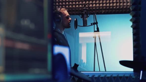 Singer with Headphones and Sound Engineer Works in Professional Recording Studio alt