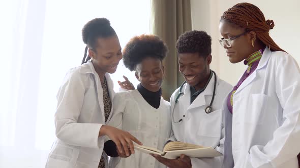 African Medical Students with Books are Discussing Something in a Hospital alt
