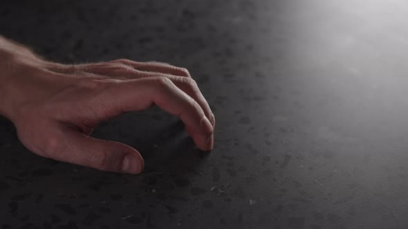 Slow Motion Young Man Hand Finger Tap on Terrazzo Countertop with Dim Light alt