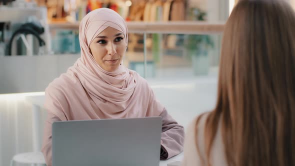 Young Arab Woman Consultant Sales Agent Bank Worker Sitting at Office Desk Advises Unrecognizable alt