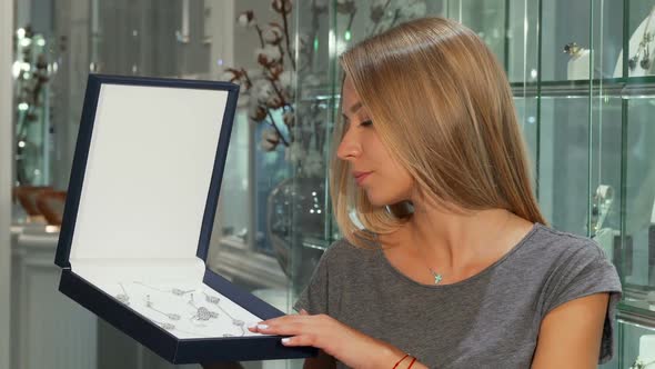 Gorgeous Happy Woman Smiling To the Camera Holding Expensive Jewelry Set alt