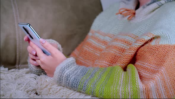 Woman Sitting on the Couch and Using the Phone Chat with Friends Read Some Information Cinematic