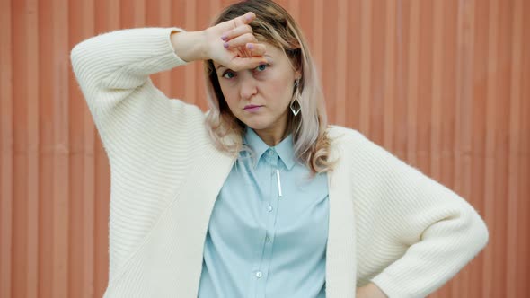 Portrait of Tired Woman Suffering From Headache Touching Head and Sighing Outdoors alt