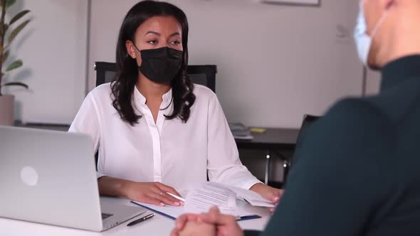 People with Medical Mask Communicate at Table in Office with Spbi Document alt