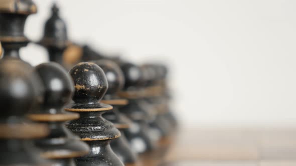 Row of chess set figures arranged on  game table close-up 4K 2160p 30fps UltraHD  footage - Black pl alt