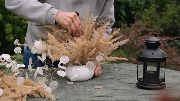 Florist Makes Autumn Flower Arrangement Using Dried Flowers alt