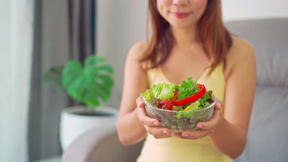 Young woman eating homemade healthy salad at home