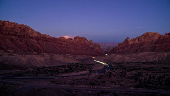 Day to night time lapse of traffic driving on winding road through Utah alt
