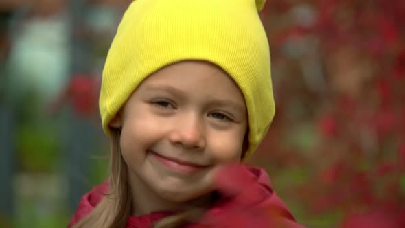 Girl Looks at Camera and Smiles in Autumn Garden
