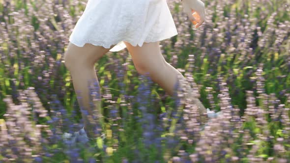 Unknown Girl Legs Running at Sunrise Meadow on the Lavender Flowers