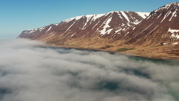 Drone Over Clouds Over Fjord Towards Mountains alt