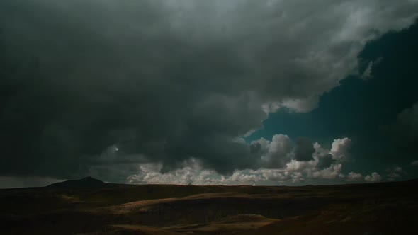 dramatic iceland landscape,fast moving clouds, wide shot with volcanic peak in a distance, timelapse