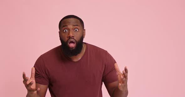 Young African American Man Yell and Point with Finger on Pink Background alt