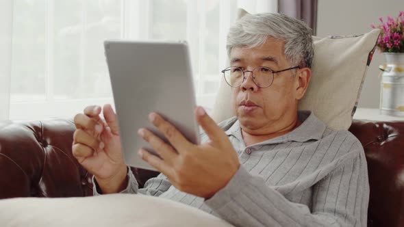 Senior man doze asleep while listening music on couch alt