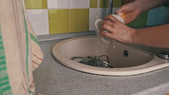 Girl's Hands are Washing Cup with Washcloth and Detergent in Full Sink Slowmo alt