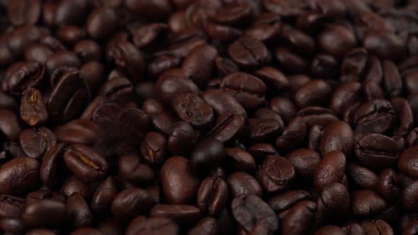 slow motion of roasted coffee beans falling down and rotating