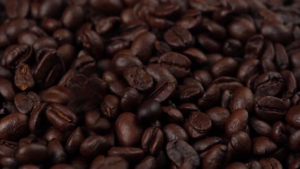 slow motion of roasted coffee beans falling down and rotating alt