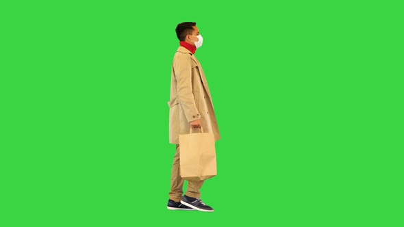 Man Walk From Shopping Wear Medical Mask Guy in Trench Carry Bags From Store in Covid19 Epidemic on