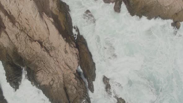 Aerial view of a small inlet being hit by the waves alt