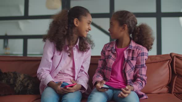 Cheerful Sisters Playing Staring Contest at Home alt