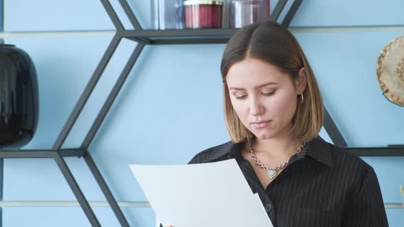 A woman looks at documents in her office. She does her own business alt