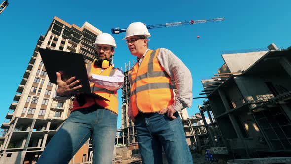 Male Engineers Are Operating a Laptop at the Construction Yard alt
