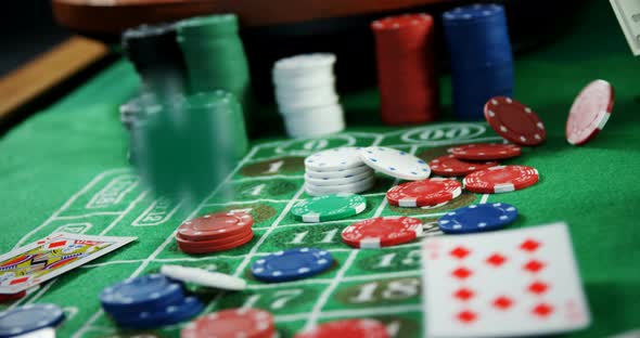 Roulette wheel, dollar, casino chips and playing cards on roulette 4k alt