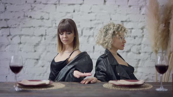 Argued Lesbian Couple Making Peace Sitting Back to Back Touching Hands alt