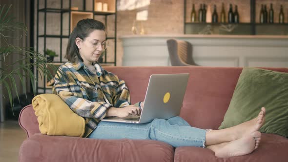 Content Woman Sitting With Laptop At Home alt