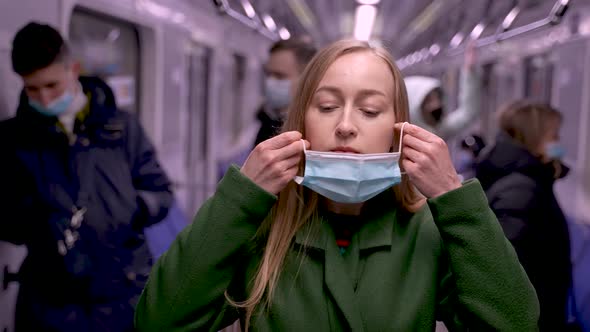 Law Abiding Female Wearing Face Mask in Subway Car alt