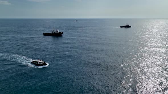 Tugs help the gas tanker to go to sea aerial view 4 K Turkey Alanya alt