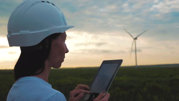 Woman Engineer Working in Wind Turbine Electricity Industrial at Sunset alt