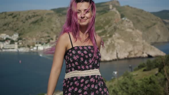 Video Portrait of a Bright Girl with Purple Hair Who Stands in the Mountains