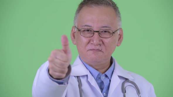 Face of Happy Mature Japanese Man Doctor Giving Thumbs Up alt