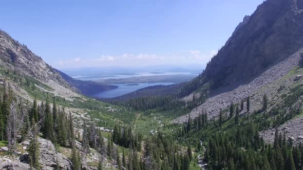 Camera flies through mountain valley towards lakes in the distance alt