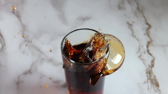 Ice Cube Falls Into the Cola and Splashes